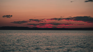 Bright red and dark gray skies over ocean