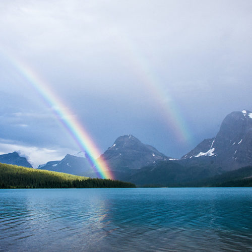 Double rainbow over mountains and lake